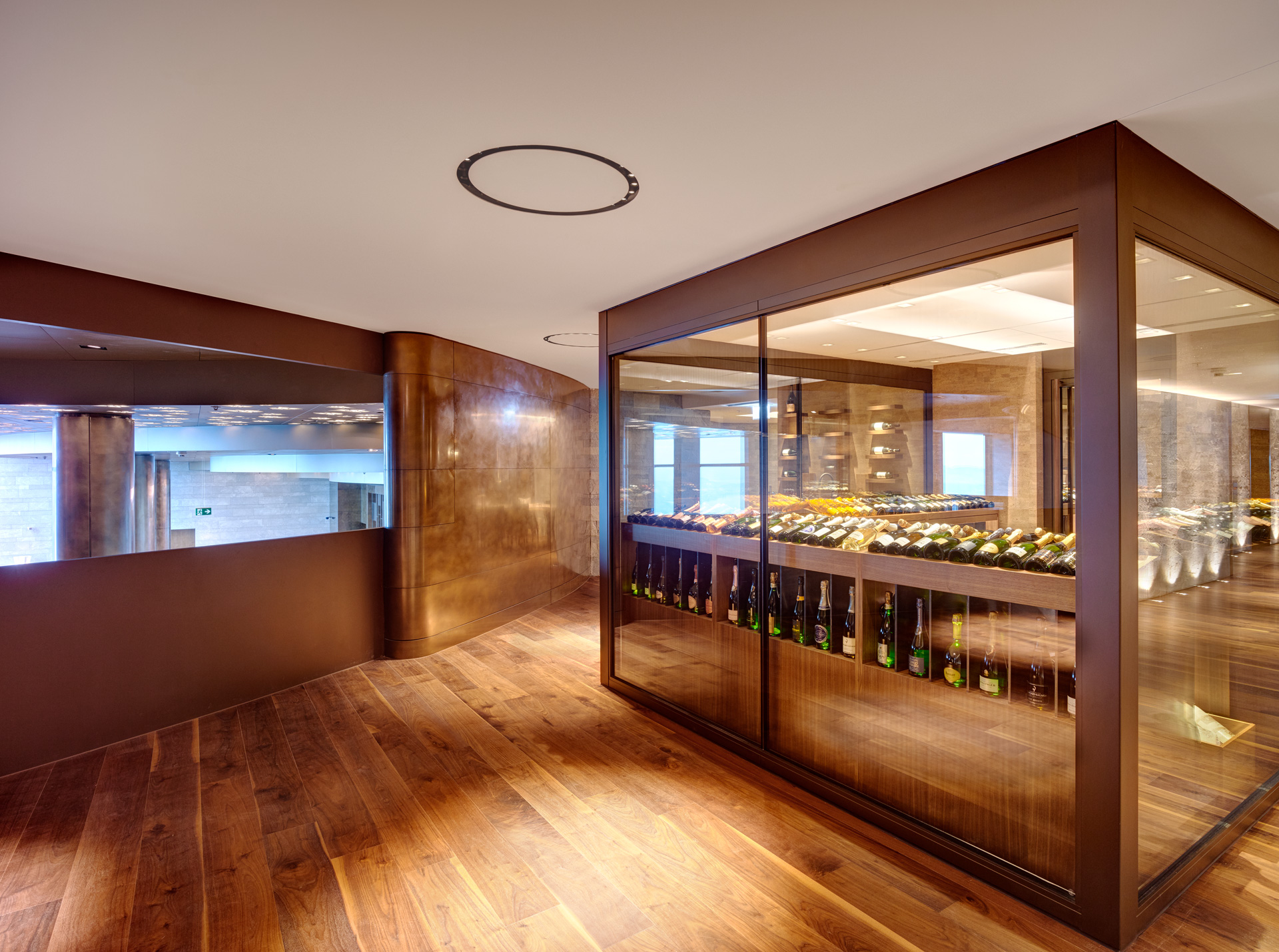 Wine storage inside the Hotel Bürgenstock. Wines are inside a cube-like space with large glass sheets. Edges are made from semi-matte Nordic Décor copper. Walls outside the wine storage are made from Nordic Décor copper and they have mixed parts of matte and glossy finishes.