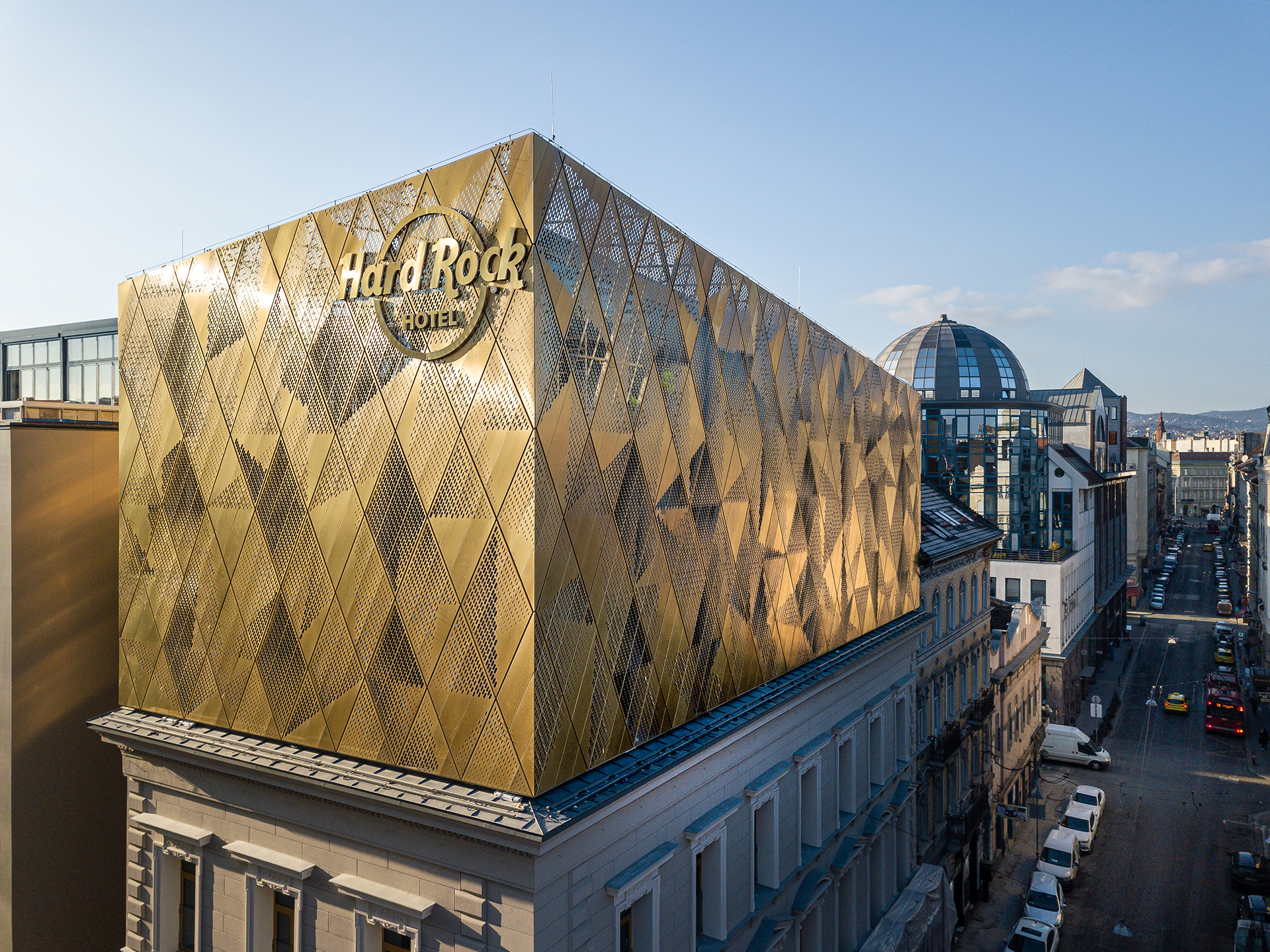View of the main corner of the Hard Rock hotel located in Budapest, Hungary. The Hard Rock logo is visible in the corner. The gold-coloured walls are clad from Nordic Royal copper.